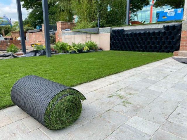 rolled up artificial grass in back garden